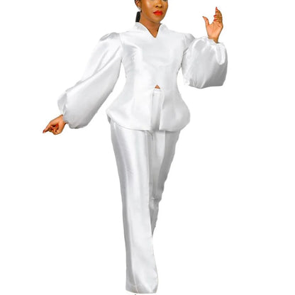 White outfit with long sleeves and pants on a white background. Women's 2-piece pants set with solid satin blouse, straight high-waist trousers. Office lady luxury outfit for professional and elegant occasions.