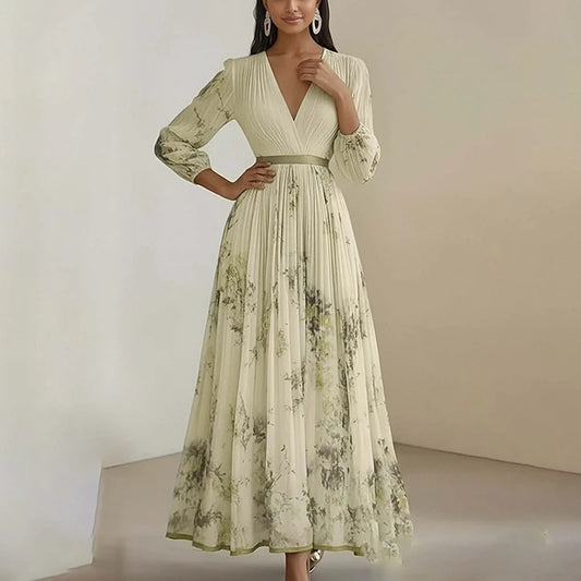 Woman wearing a long, light-colored dress with floral pattern against a plain background