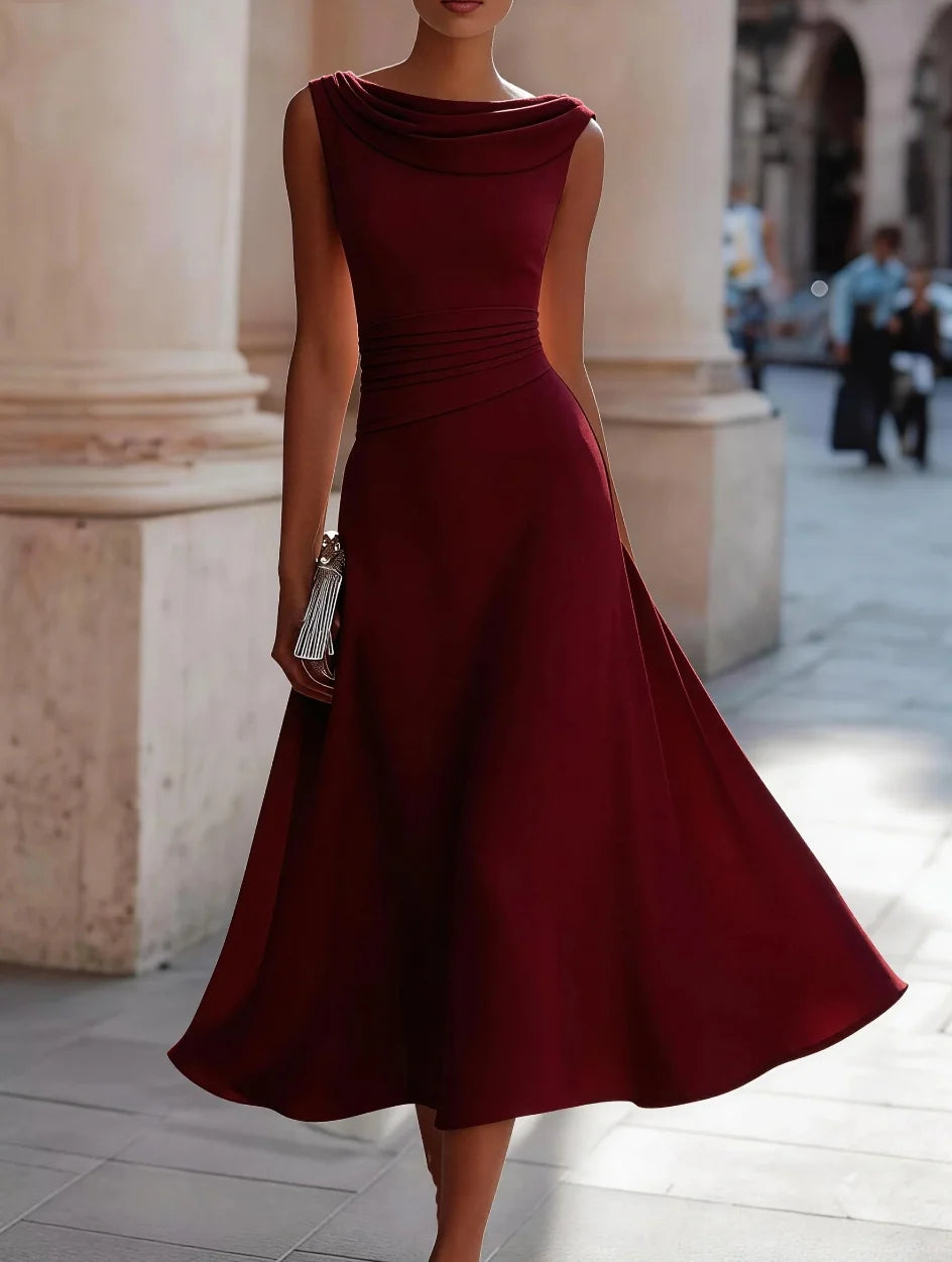 Burgundy dress worn by a person standing in an outdoor setting with columns.