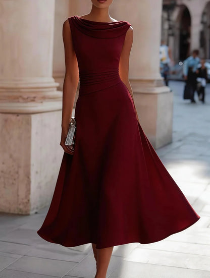 Burgundy dress worn by a person standing in an outdoor setting with columns.