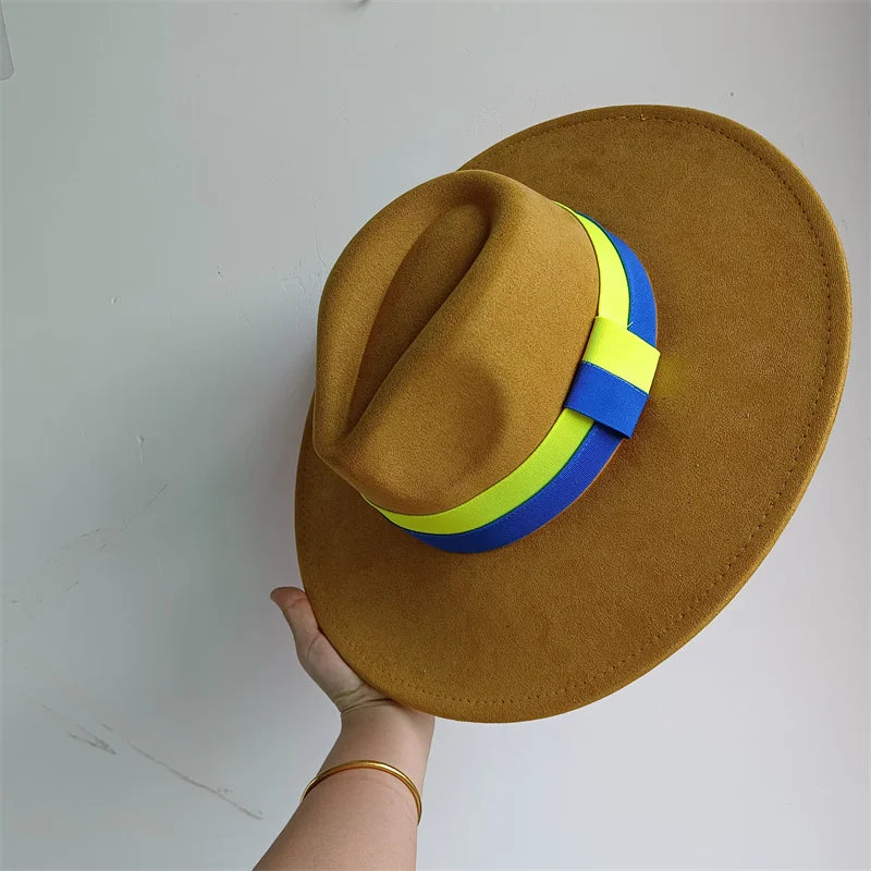 Brown hat with a blue and yellow band held by a hand on a white background