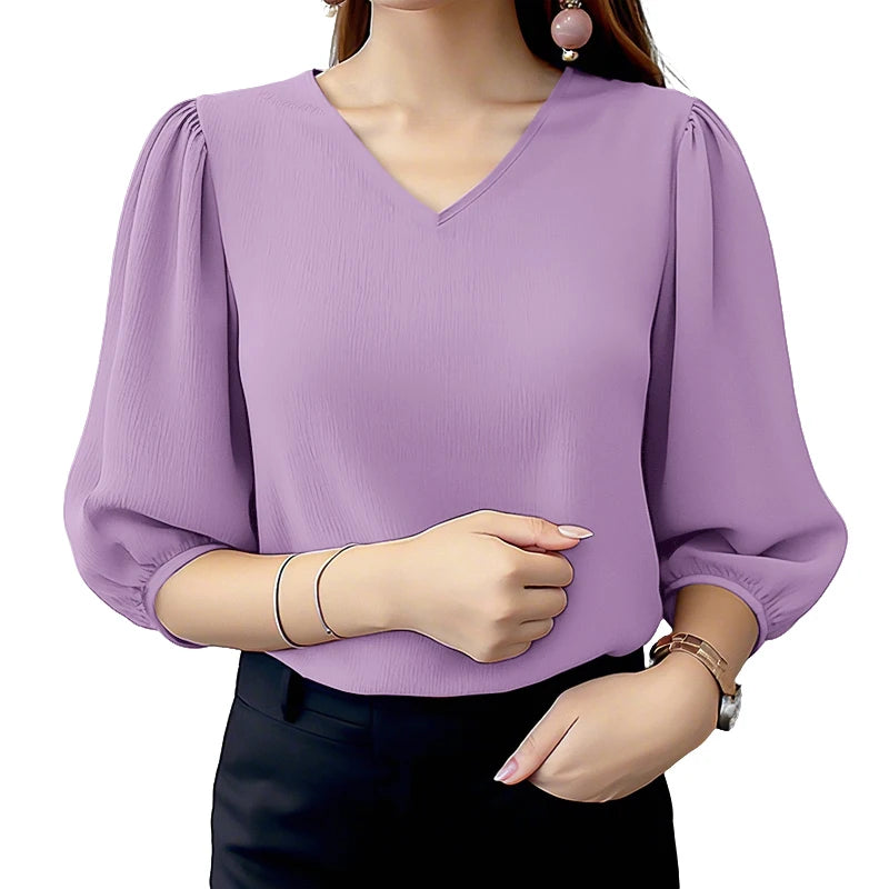 Purple blouse with puffed sleeves worn by a person on a white background