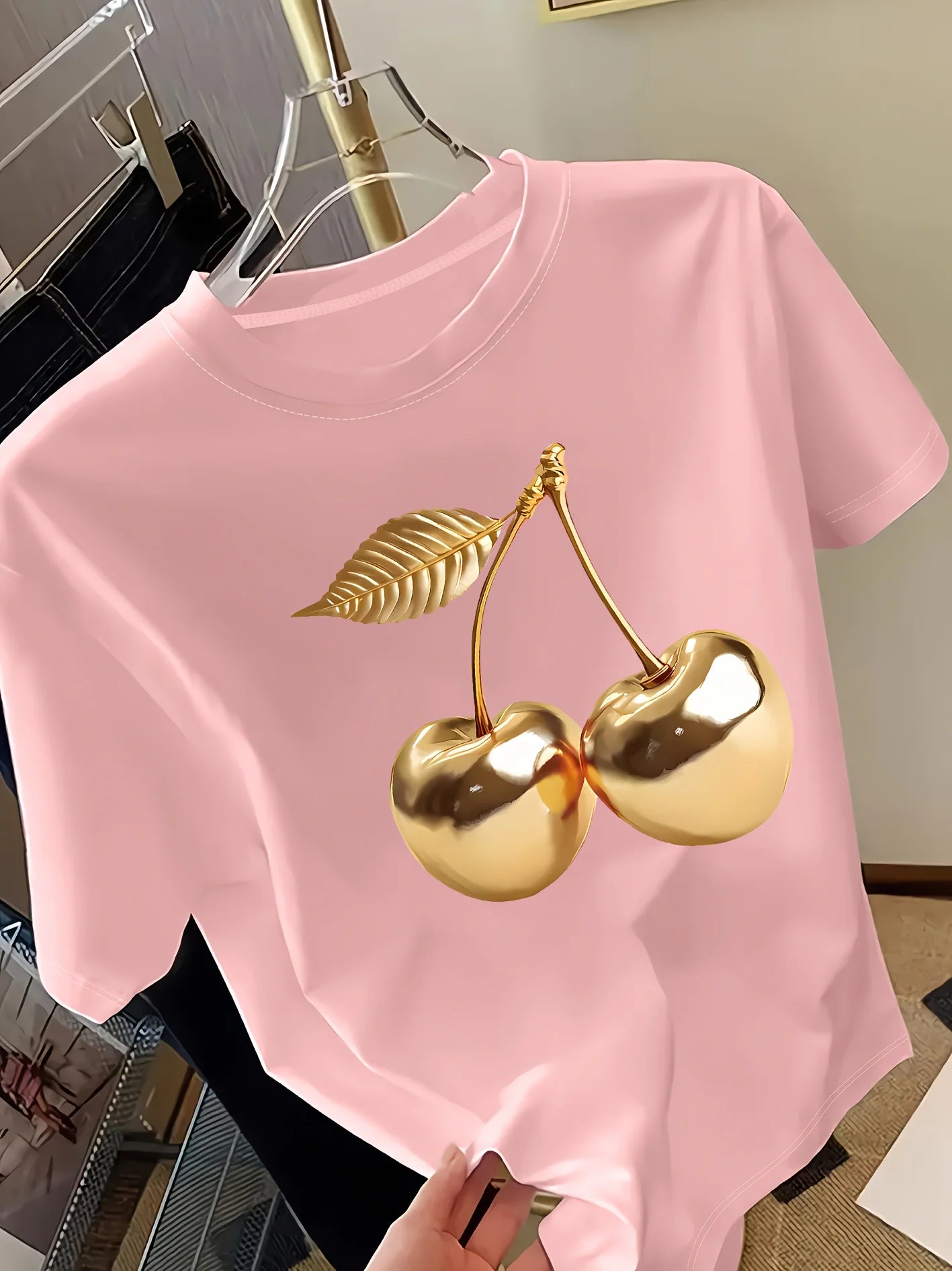 Women's pink short sleeve t-shirt with gold metallic cherry print on hanger