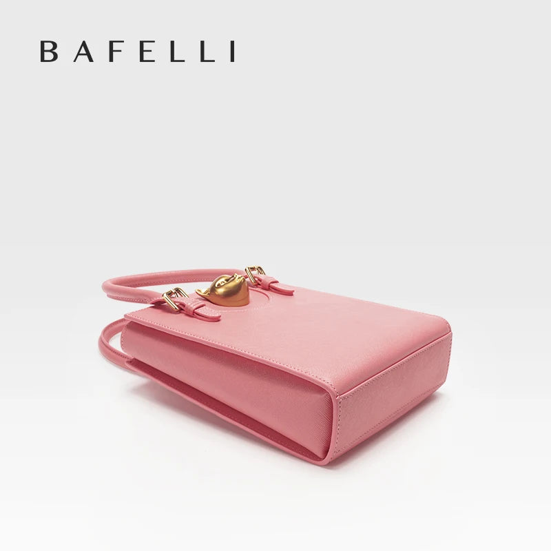 Pink handbag with gold handle and clasp on a light gray background, featuring the brand 'Bafelli'. Unisex mini tote crossbody bag in split leather with flap pocket and lock closure. Hard box shape and polyester lining. Casual versatile style.