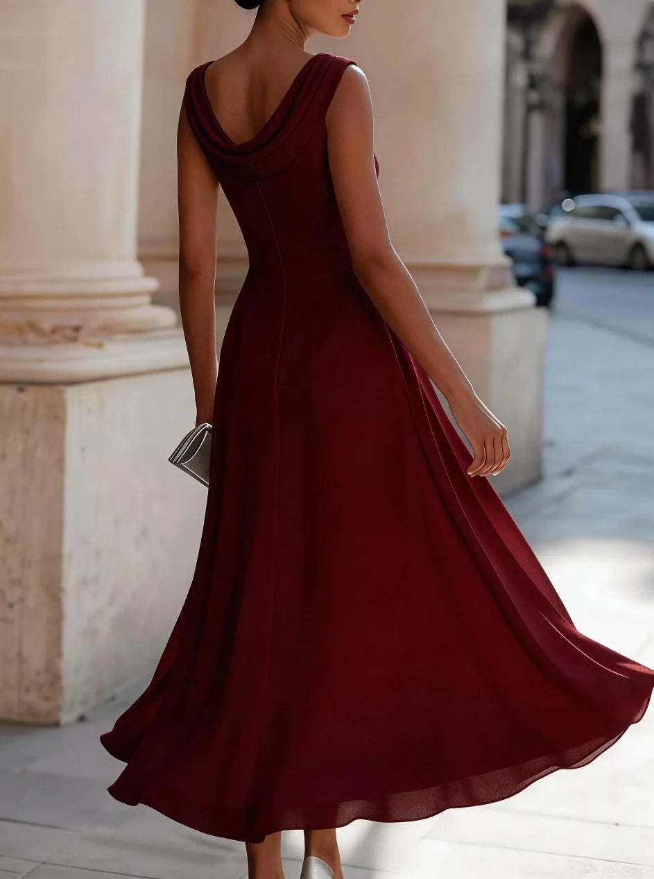Woman in a burgundy dress walking on a city street.