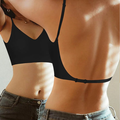 Two people wearing black bras against a neutral background