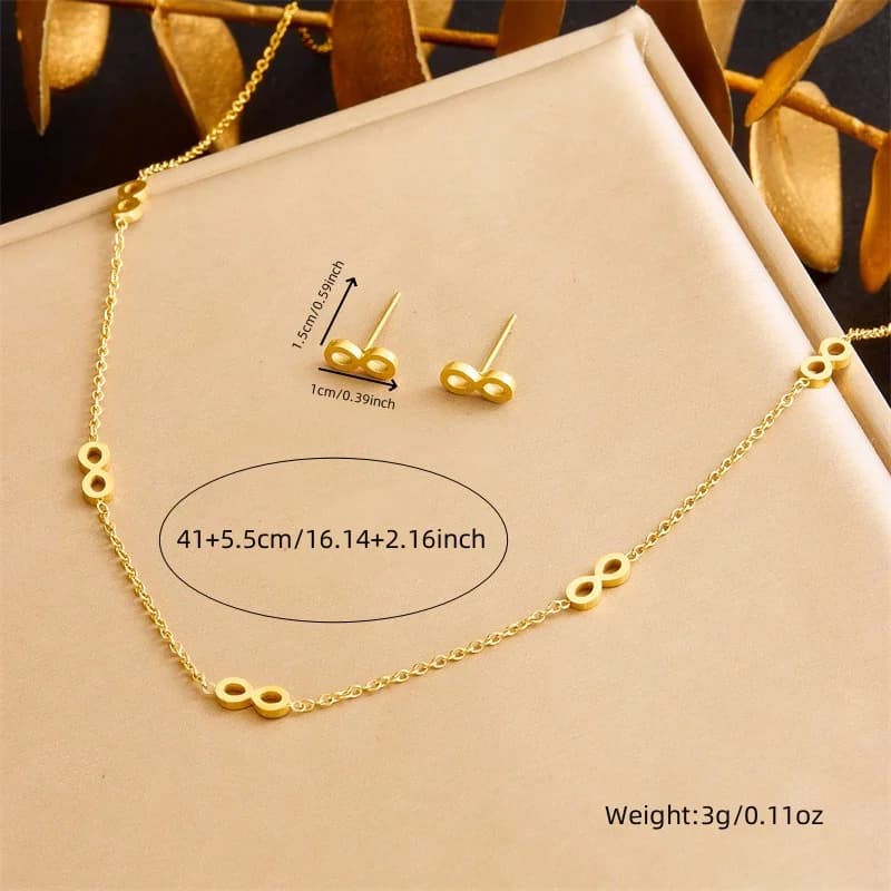Gold necklace and earrings on a beige display box with measurements and weight details.