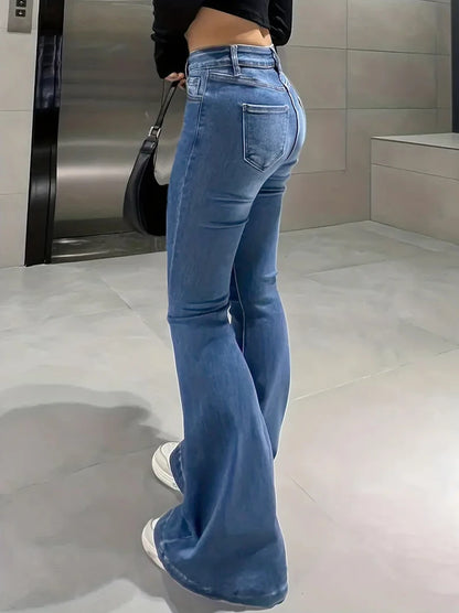 Person wearing blue jeans in a bathroom setting. Women’s slim trumpet jeans mid waist in stretchy soft denim. Casual bell bottoms style with enzyme wash, perfect for UK fashion.