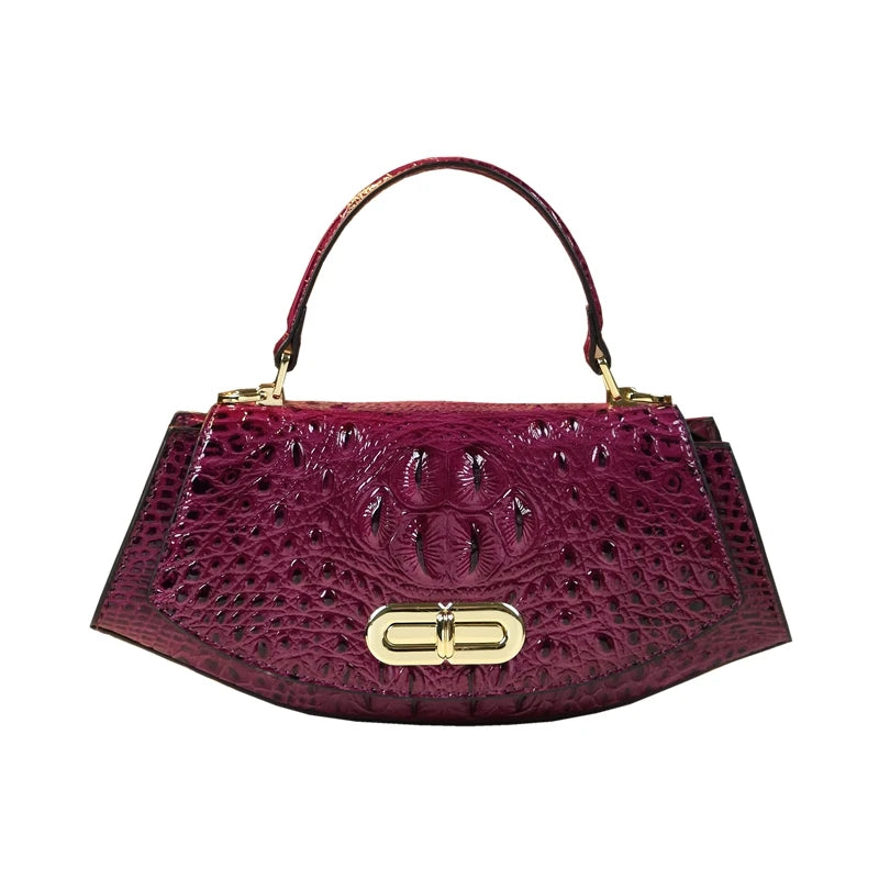 Purple crocodile skin handbag with gold clasp on a white background