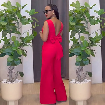 Woman in a red jumpsuit standing between two potted plants indoors. Women’s striped print blouse and elastic waist pants two-piece suit. Sleek, comfortable, breathable office wear perfect for spring and summer.