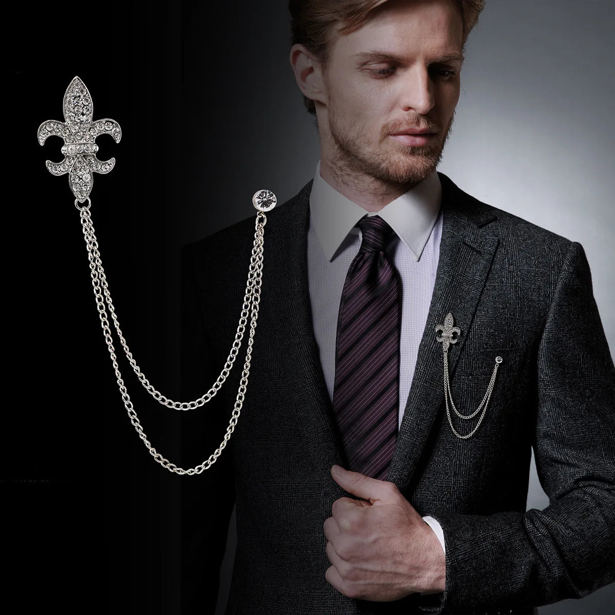 Man wearing a suit with a decorative chain accessory on a dark background. Elegant rhinestone lapel pins for men and women. Tassel, crown, floral pins for suits, collars, weddings, parties. Zinc alloy metal, classic style.