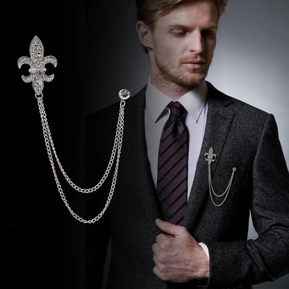 Man wearing a suit with a decorative chain accessory on a dark background. Elegant rhinestone lapel pins for men and women. Tassel, crown, floral pins for suits, collars, weddings, parties. Zinc alloy metal, classic style.