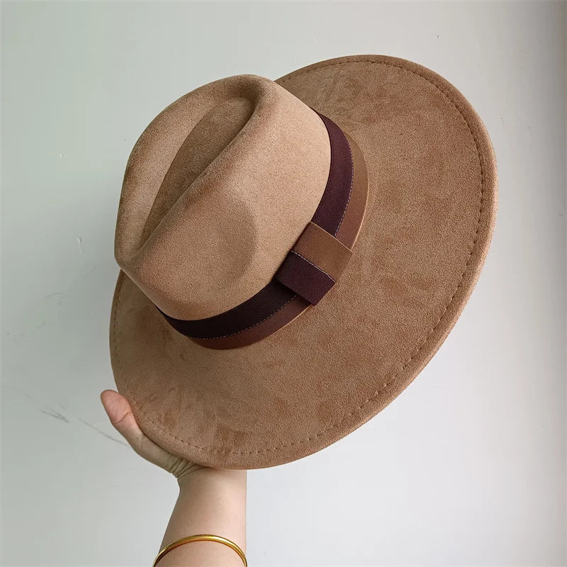 Brown fedora hat with a wide brim held against a plain background