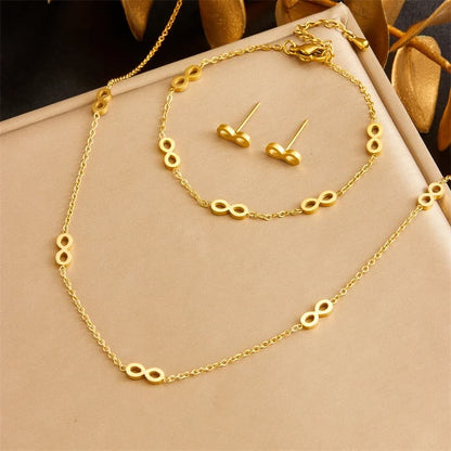 Gold necklace and earrings set on a beige background