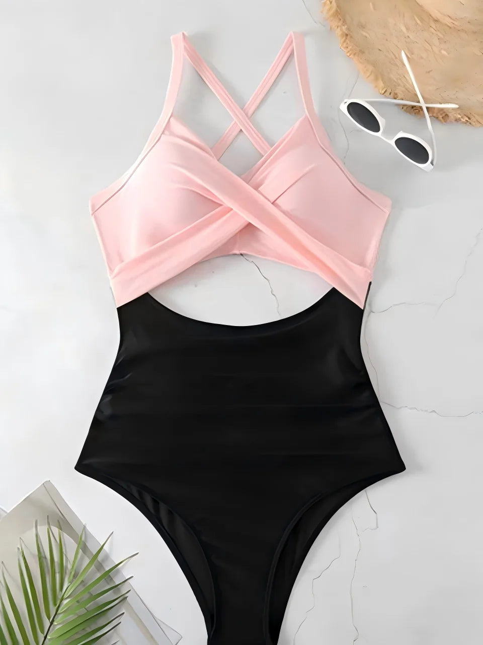 Black swimsuit with pink top on a light gray surface