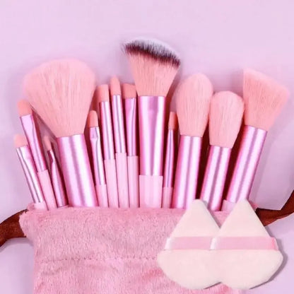 Set of pink makeup brushes with a pink pouch on a light purple background. Soft fluffy makeup brush set with wool fiber bristles and plastic handles. Complete set for powder, foundation, eyeshadow, and beauty blending.