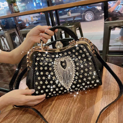 Black handbag with rhinestone embellishments held by a person in a casual setting. Large genuine leather dumpling bag with diamond rhinestone clip and lock clasp. Soft handle, multiple compartments. Fashionable shoulder tote for women.