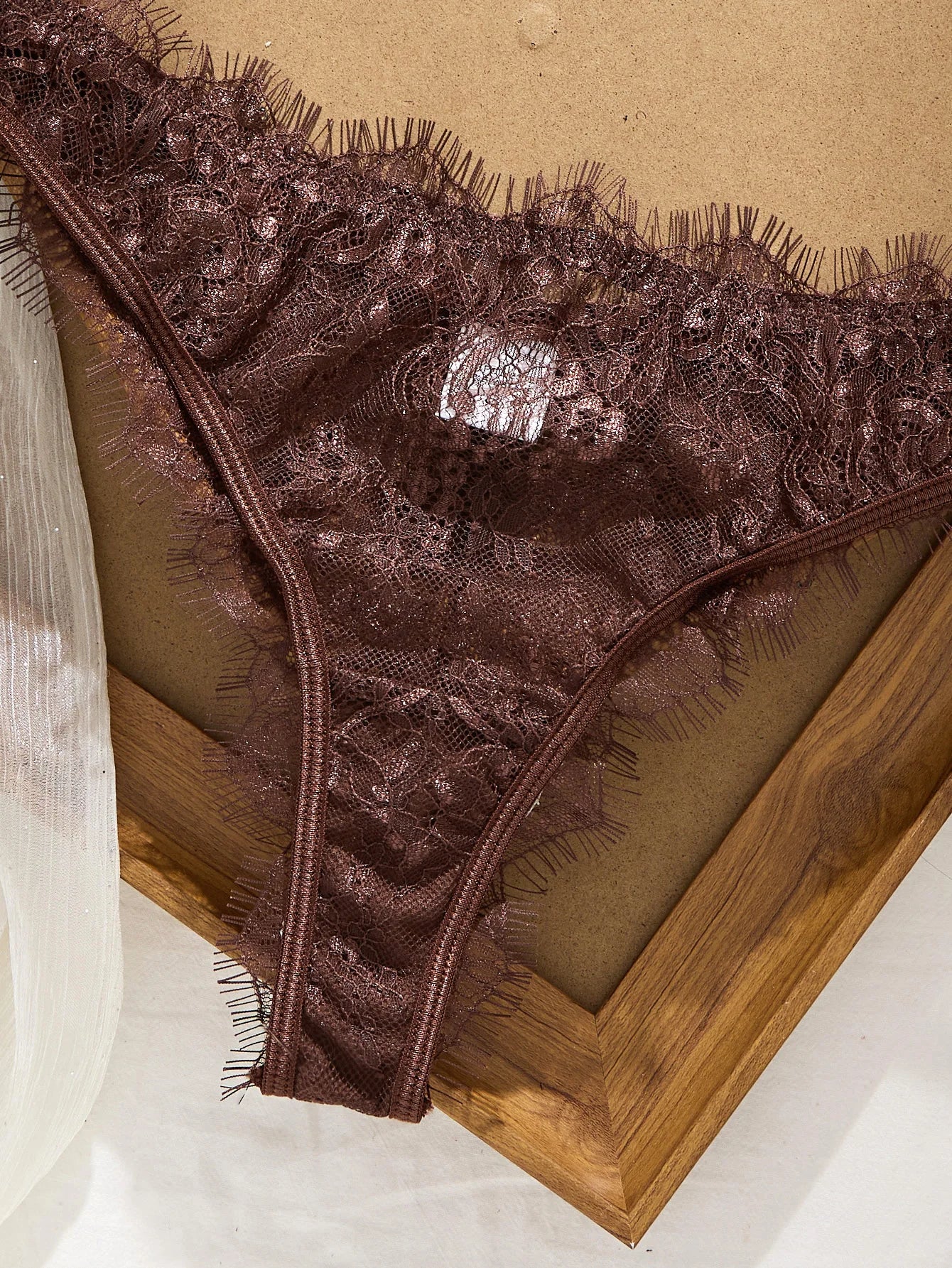 Brown lace lingerie on a wooden surface