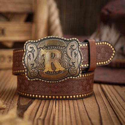 Brown leather belt with gold and silver buckle featuring a large 'R' on a wooden surface.