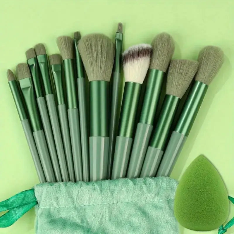 Set of green makeup brushes with a green sponge on a light green background. Soft fluffy makeup brush set with wool fiber bristles and plastic handles. Complete set for powder, foundation, eyeshadow, and beauty blending.