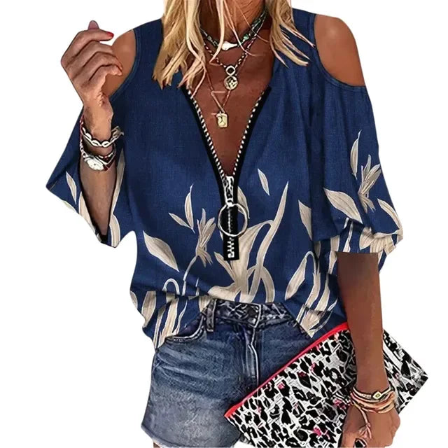 Woman wearing a blue floral blouse with a leopard print clutch on a white background