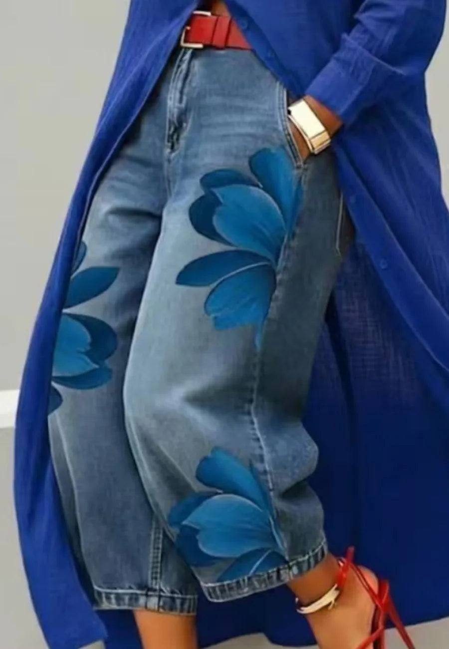 Person wearing a blue floral-patterned coat over a blue denim jacket with floral designs.