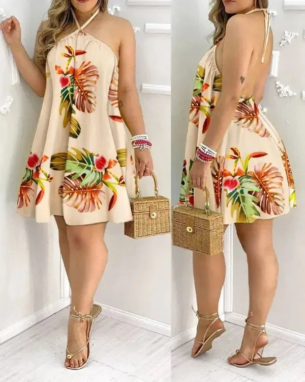 A model wearing a chic tropical print mini dress with vibrant floral patterns on a beige background. The summer dress features spaghetti straps and an above-knee length.