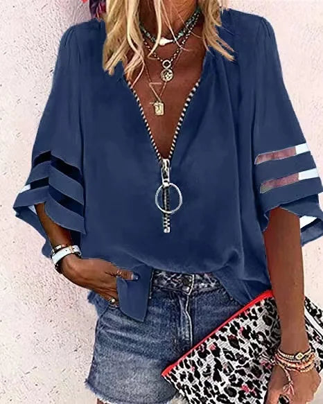 Woman wearing a blue zip-up top with denim shorts and a leopard print clutch.