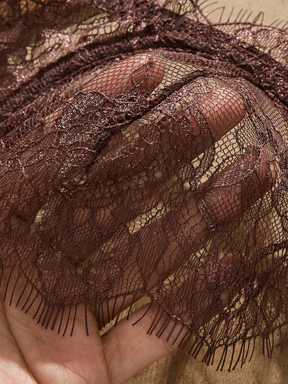 Close-up of brown lace fabric held by a hand