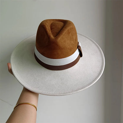 Brown and beige hat held by a hand on a light gray background