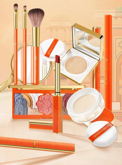 Makeup set with orange and gold accents on a beige background. Christmas makeup gift box with BB cream, lipstick, eyeshadow, eyebrow pencil, and brushes. Holiday beauty set for women & girls.
