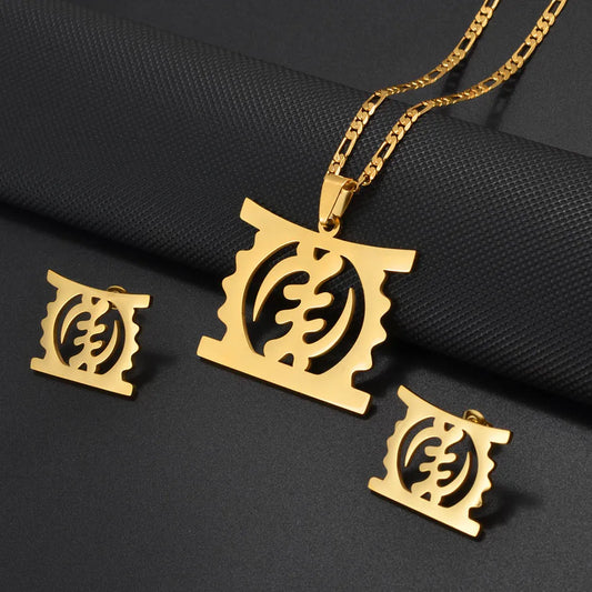 Gold-tone jewelry set featuring a pendant necklace, matching earrings, and a chain, all with a cutout circular emblem design, displayed on a dark textured background.
