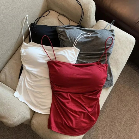 Three sleeveless tops in white, black, and red on a beige couch. Corset taille cintrée élégant, sans manches avec pliage, coussinet poitrine, bretelles fines, top court solide, mode UK FTF Market.