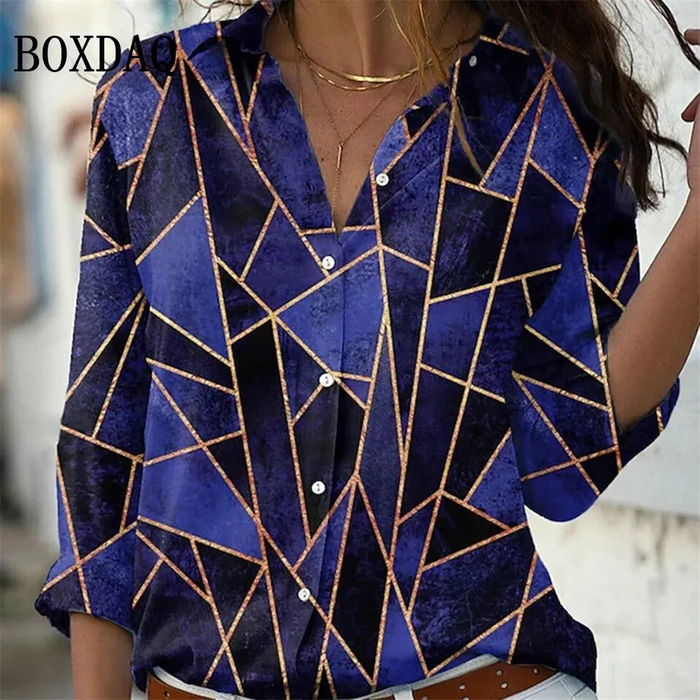 A woman wearing a blue patterned button-up shirt with gold geometric lines, shown from the chest down in a lifestyle setting.