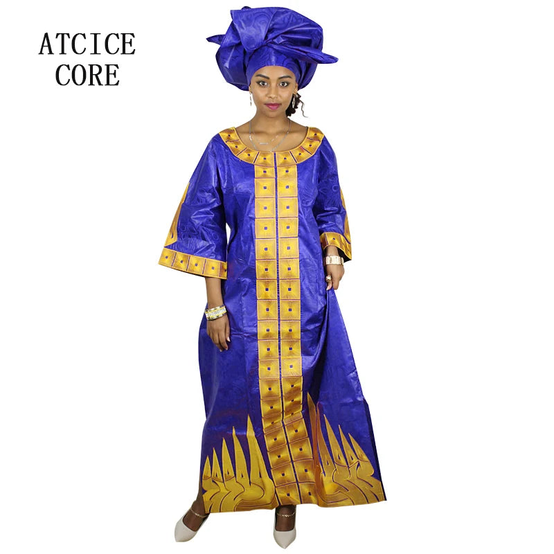 Woman wearing a blue and gold traditional outfit with a matching headwrap on a white background.