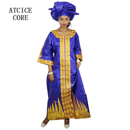 Woman wearing a blue and gold traditional outfit with a matching headwrap on a white background.