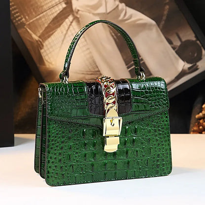Green crocodile-patterned handbag with a gold lock on a light surface. Small genuine leather crocodile crossbody bag. Hard flap design with soft handle, zipper closure, and interior phone & compartment pockets.