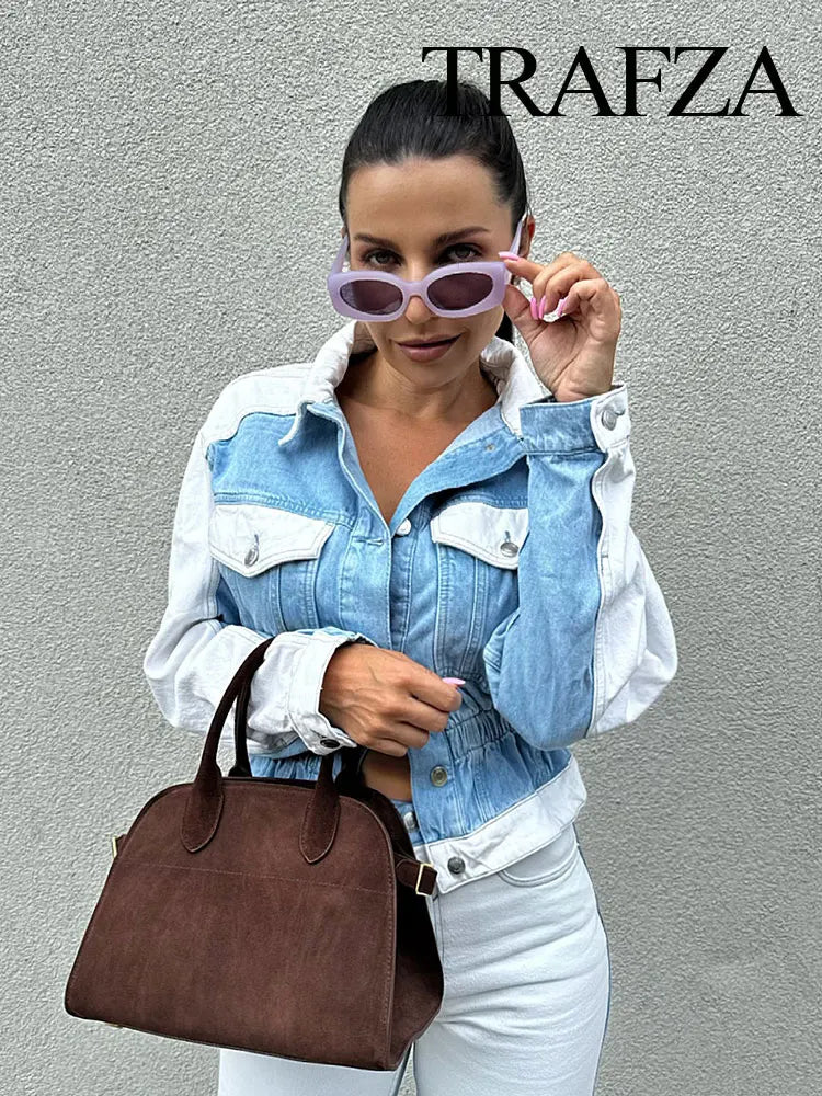 Woman wearing a denim jacket and sunglasses, holding a brown handbag against a gray background with 'TRAFZA' branding. Women’s 2-piece denim jacket and straight jeans set. Patchwork design, mid waist, turn-down collar, button closure, loose casual fit, streetwear.