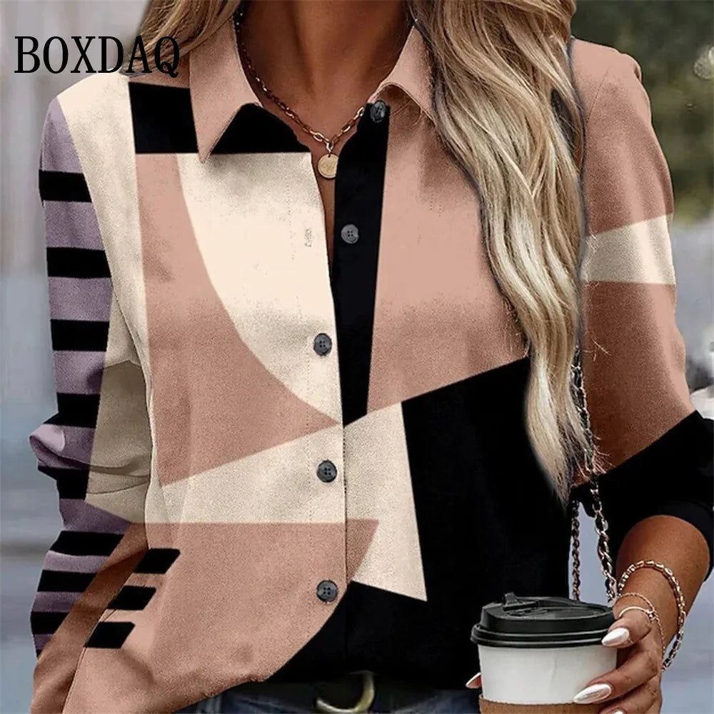 A woman wearing a geometric print button-up blouse with pink, beige, black, and lavender sections, holding a takeaway coffee cup. The brand name BOXDAQ is visible in the top left corner.