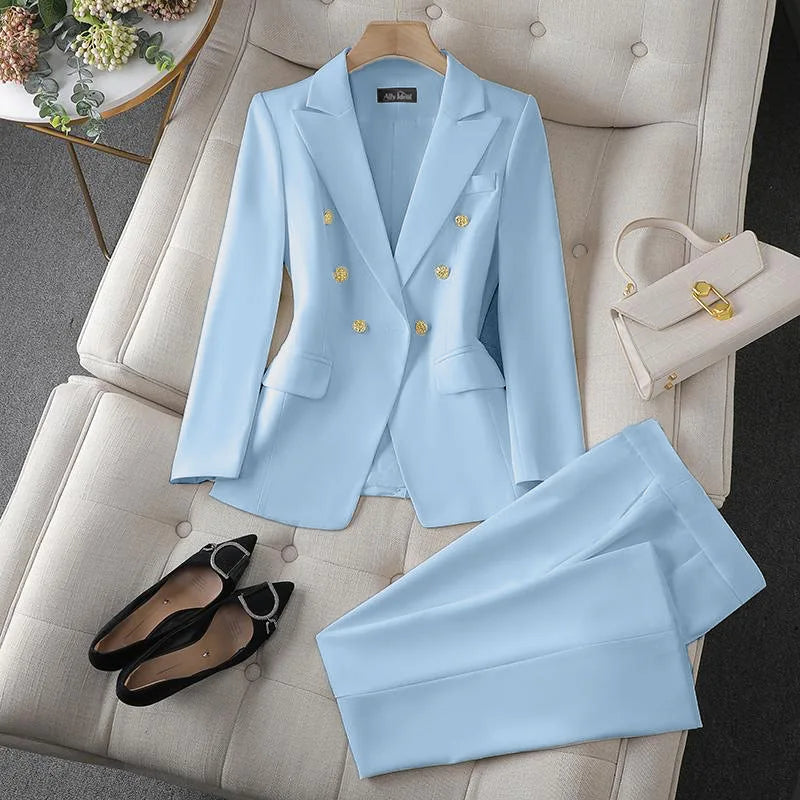 Light blue suit with gold buttons on a white chair, accompanied by black shoes and a white handbag.