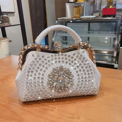 Decorative handbag with rhinestone embellishments on a wooden surface. Large genuine leather dumpling bag with diamond rhinestone clip and lock clasp. Soft handle, multiple compartments. Fashionable shoulder tote for women.