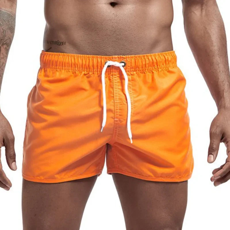 Men's orange quick-drying swimming trunks in vibrant colors for beach and surfing