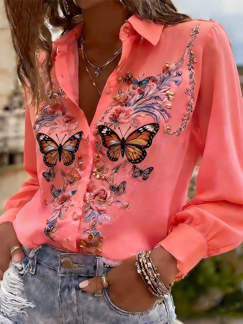 Person wearing a pink blouse with butterfly designs outdoors