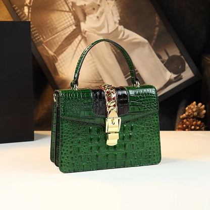 Green textured handbag with gold clasp on a neutral background. Small genuine leather crocodile crossbody bag. Hard flap design with soft handle, zipper closure, and interior phone & compartment pockets.