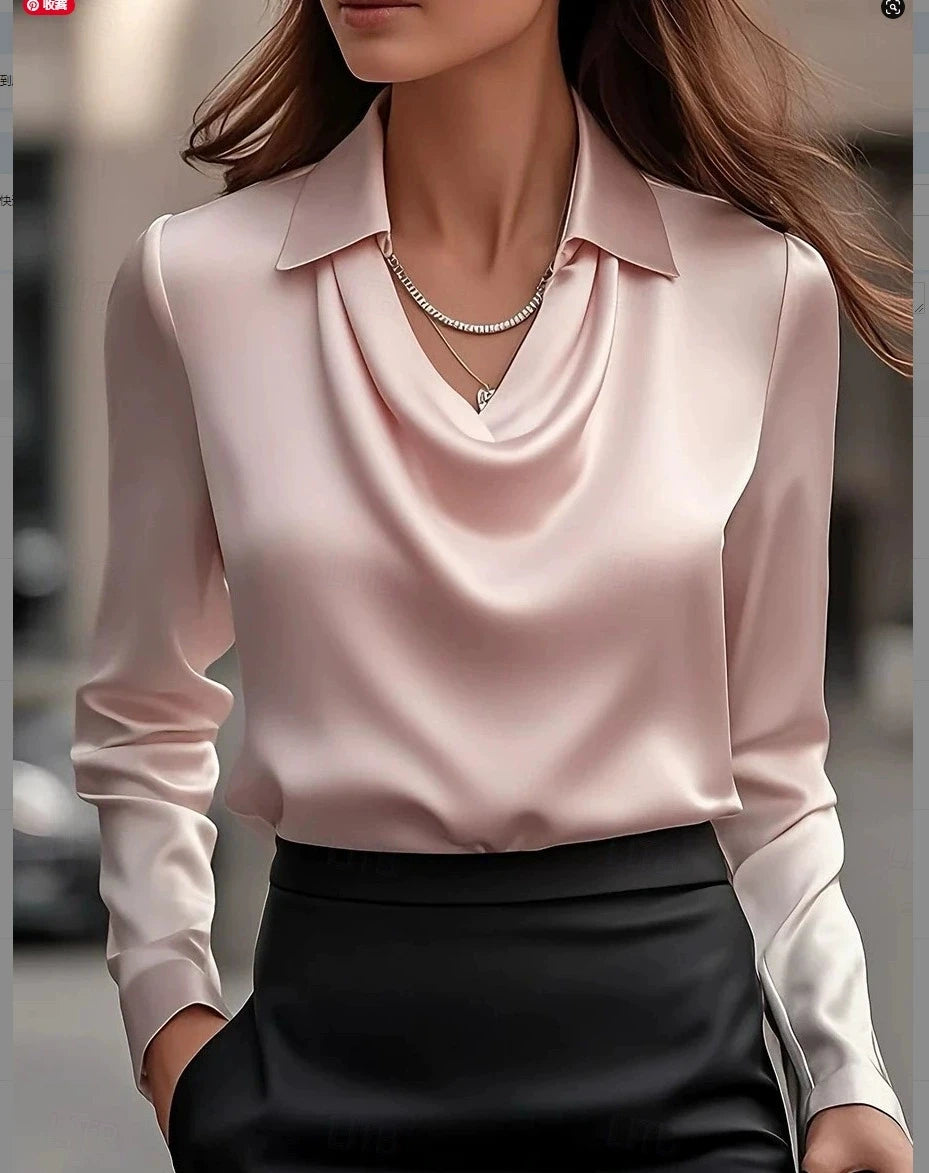Person wearing a light pink blouse with long sleeves and a black skirt.