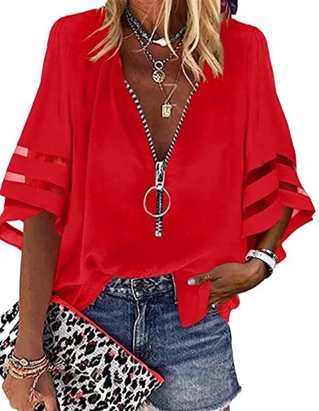 Person wearing a red blouse with a zipper, denim shorts, and a leopard print clutch.
