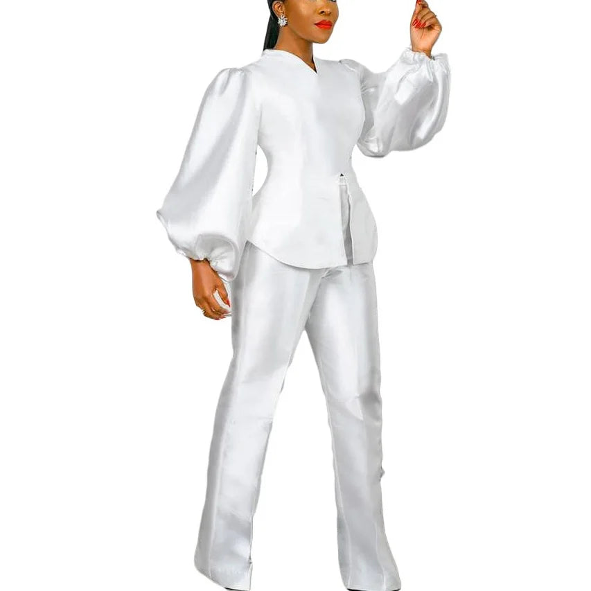 Woman wearing a white outfit with puffed sleeves on a white background. Women's 2-piece pants set with solid satin blouse, straight high-waist trousers. Office lady luxury outfit for professional and elegant occasions.