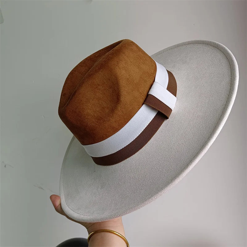 Brown and white hat with a wide brim held against a plain background