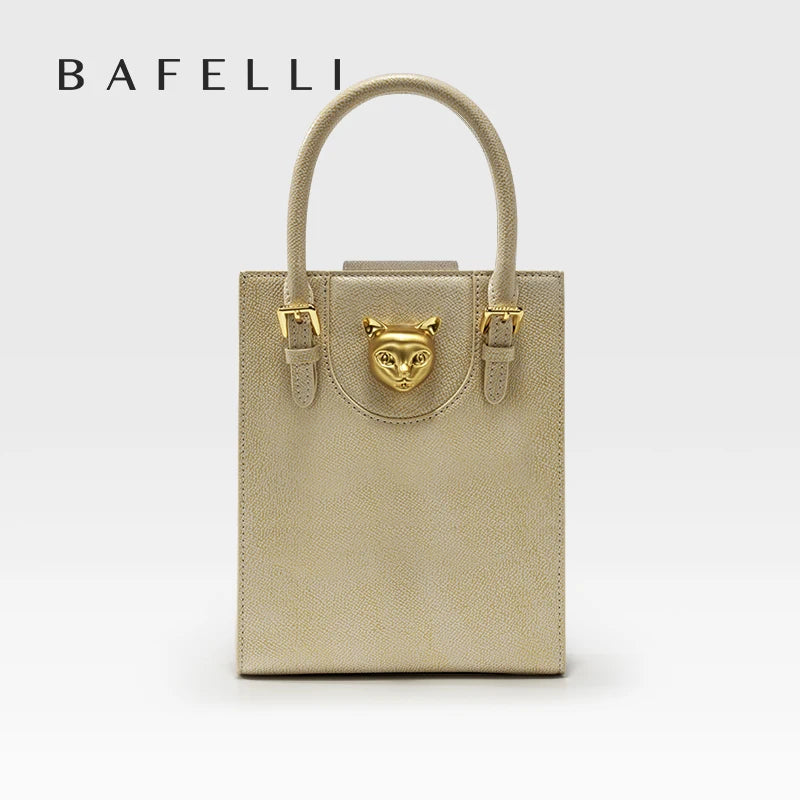 Beige handbag with gold accents and 'Bafelli' branding on a light gray background. Unisex mini tote crossbody bag in split leather with flap pocket and lock closure. Hard box shape and polyester lining. Casual versatile style.