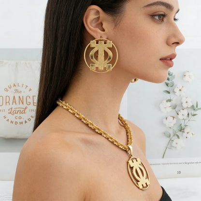 Woman wearing gold statement earrings and twisted rope necklace with African pendant
